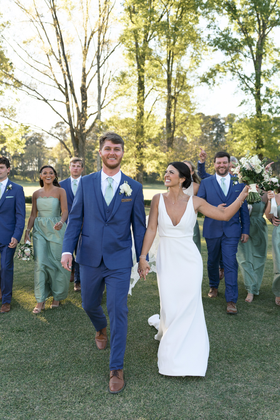 whole bridal party walking and cheering to the camera in South Carolina spring wedding day